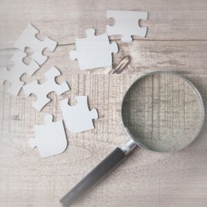 Μεγενθυτικός φακός δίπλα σε κομμάτια από puzzle